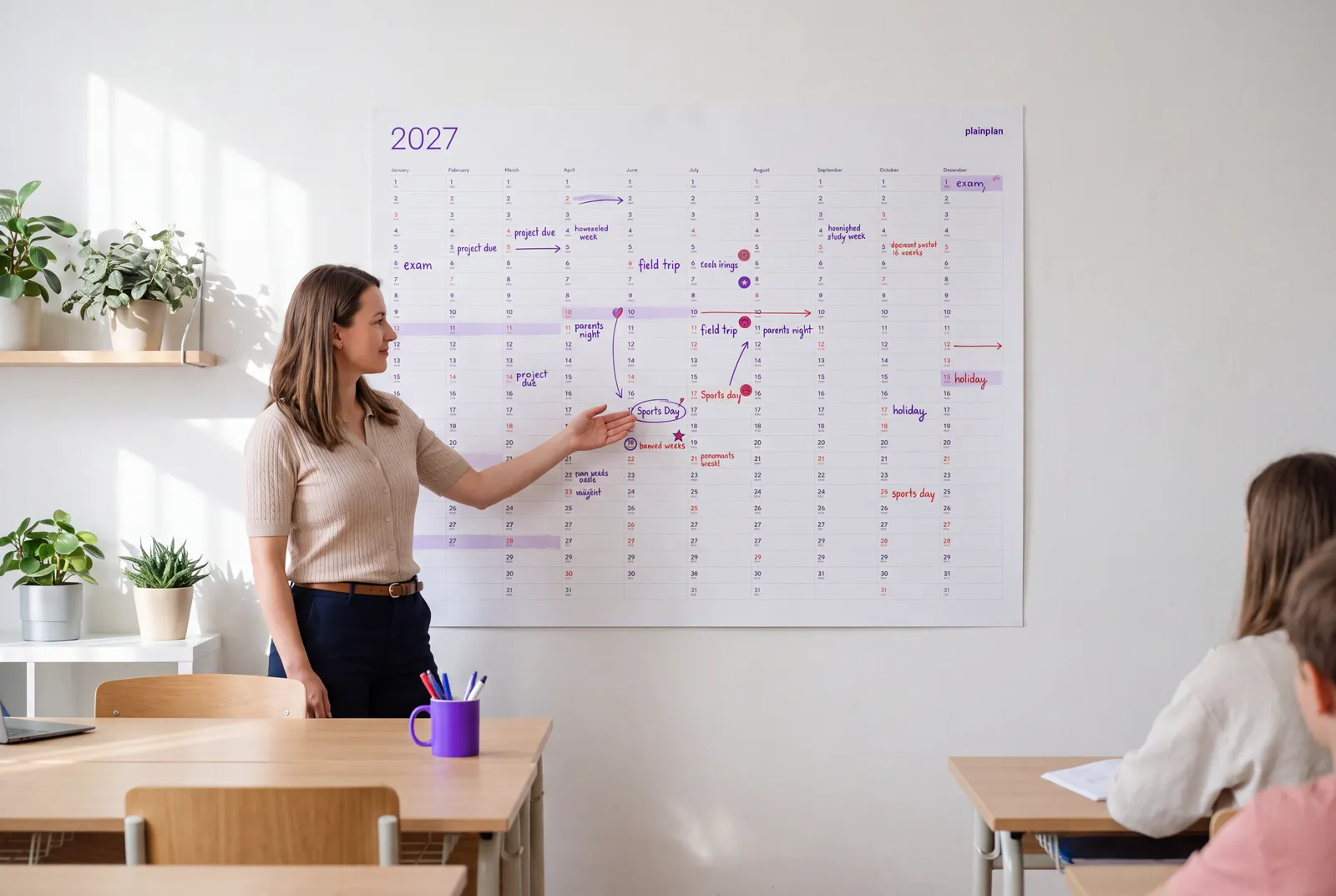 Teacher pointing at a yearly wall planner with school terms marked